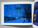 Open book showing a snowy scene with a water tower and houses.