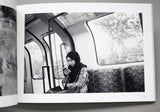 Open book showing a black and white photo of a person on a train.