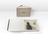 Now Is Always by Vaune Trachtman, hardcover art book shown open to a black-and-white photograph titled Salt. Salt shows the shadow of a man wearing a hat surrounded by text and a tear drop.